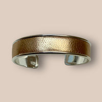 Brazalete de cuero dorado.